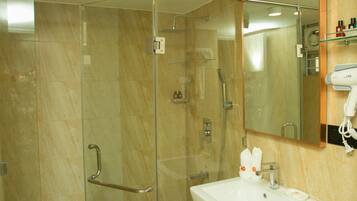 A modern bathroom with a glass-enclosed shower, a white sink, and a mirror above it.