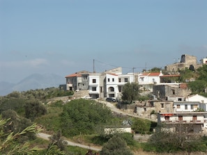 Un quartier résidentiel situé sur une colline, avec des immeubles à plusieurs étages, dont certains sont dotés de balcons, et qui offre une vue dégagée sur le paysage environnant.
