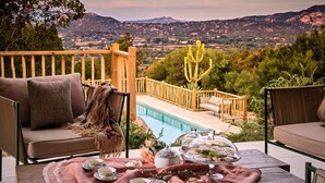 Une terrasse avec une piscine, du mobilier d’extérieur et une table préparée pour le thé.