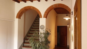 A staircase with a brick archway, a potted plant, and a wall-mounted light fixture. - 2bedrooms apartment with pool in the Chianti area, organic farm (Florence)