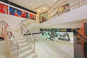 Stunning multi-level space with a staircase, balcony, and vibrant artwork.