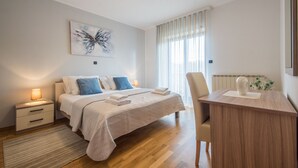 A modern bedroom with a bed, bedside tables, a desk, and a window with curtains. - Wonderful new villa, lush fenced garden, private pool (Pazin)