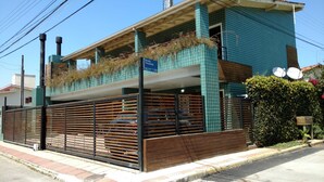 A modern building with a tiled facade, a gated entrance, and satellite dishes on the roof. - Residencial Jade (Florianópolis)