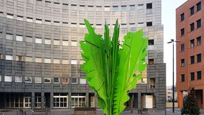 A modern building with a large green sculpture in front. - Casa Bella Skyline (Bologna)