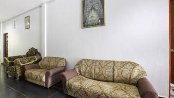 Quarto com dois sofás e um armário de madeira.