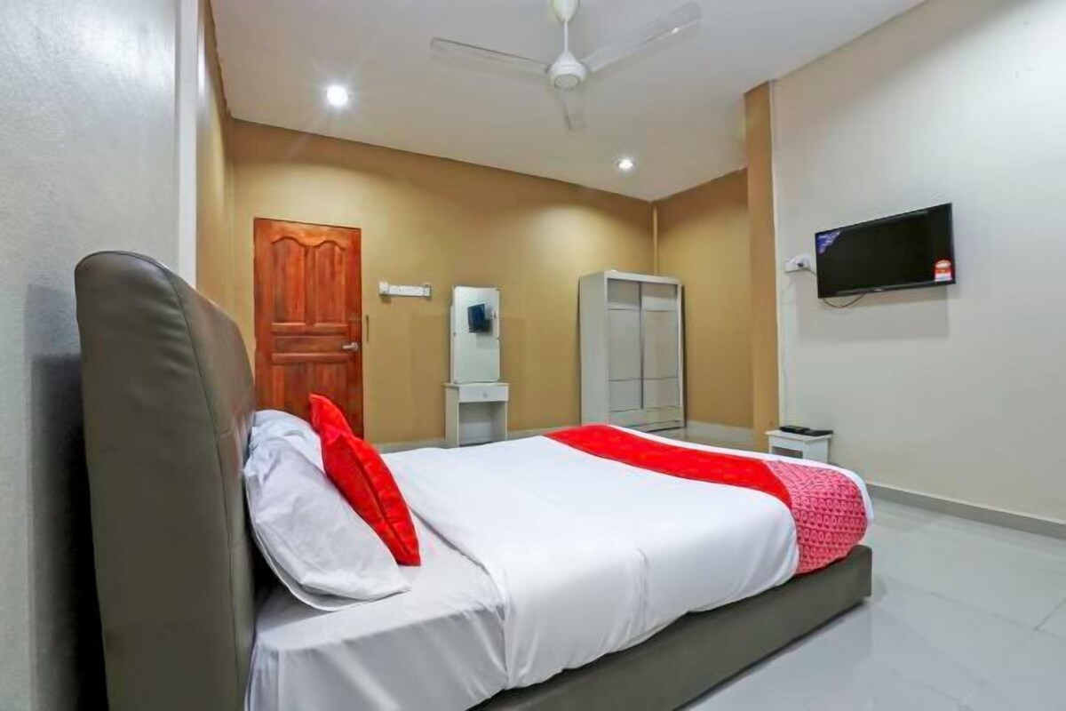 A modern bedroom with a bed, a wardrobe, a television, and a ceiling fan.