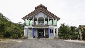 A two-story building with a balcony, a flag, and a sign that reads "YTO".
