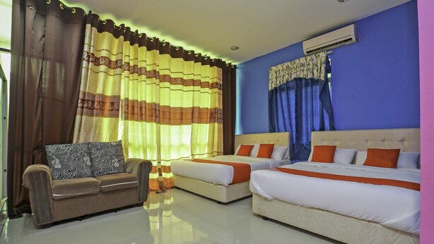 A hotel room with two beds, a sofa, and a window with curtains.