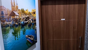 A wooden door with a small label and a framed painting of a canal scene with boats and buildings. - Porto Paolo side sea view ( Condominium ) (St. Paul's Bay)