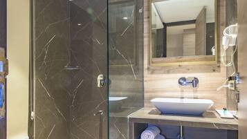 A modern bathroom with a glass-enclosed shower, a wooden vanity, and a large mirror.
