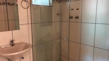 Quarto duplo luxo | Banheiro | Chuveiro, toalhas de banho, sabonete, papel higiênico