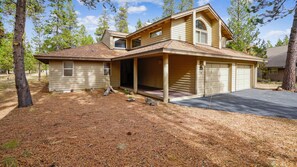 A two-story house with a covered porch, a garage, and a driveway. - 13 Modoc-Sunriver, Oregon: Hot Tub, BBQ, WiFi, Ping Pong, Foosall, SHARC Aquatics, Tubing Hill, Mt. Bachelor, Golf, Deschutes River, Tennis, Bike Paths (Sunriver)