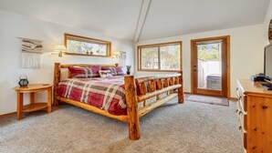 A bedroom with a wooden bed, two bedside tables, a dresser, and a large window. - 13 Modoc-Sunriver, Oregon: Hot Tub, BBQ, WiFi, Ping Pong, Foosall, SHARC Aquatics, Tubing Hill, Mt. Bachelor, Golf, Deschutes River, Tennis, Bike Paths (Sunriver)