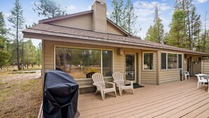 A cabin with a deck, large windows, and outdoor seating. - 13 Modoc-Sunriver, Oregon: Hot Tub, BBQ, WiFi, Ping Pong, Foosall, SHARC Aquatics, Tubing Hill, Mt. Bachelor, Golf, Deschutes River, Tennis, Bike Paths (Sunriver)