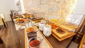 A buffet setup with various food items and condiments. - Hotel Paradise Residencial (Capdepera)