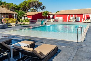 Una piscina con sillas de descanso y un tobogán de agua.