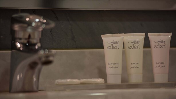 A bathroom sink with three Eden brand toiletries: body lotion, bath gel, and shampoo. - Hotel Asmara Palace (Asmara)