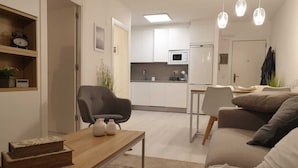 A modern living room with a sofa, a coffee table, and a dining area.
