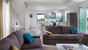 Ein modernes Wohnzimmer mit zwei Sofas, einem Couchtisch und Blick in die Küche.