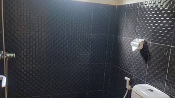 Un baño con inodoro, bidé y ducha.