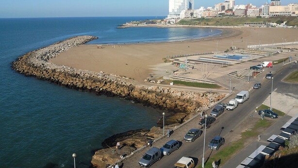Eine Küstenstraße mit Strand und Felsenmole.