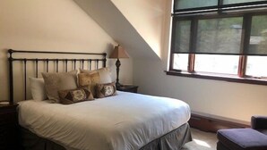 A bedroom with a bed, pillows, a nightstand, a lamp, a window, and a chair. - Luxurious 1br+loft - Ski-in/ski-out Access To Beaver Creek 1 Bedroom Condo by RedAwning (Avon)