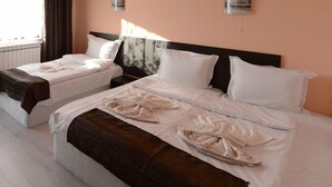 Habitación de hotel con dos camas, cada una con ropa de cama y toallas blancas.