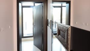Un pasillo con una puerta oscura que da a una habitación luminosa.