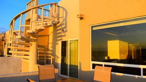 Un bâtiment moderne doté d’un escalier en colimaçon, de grandes portes coulissantes en verre et du logo de FMI Rentals.