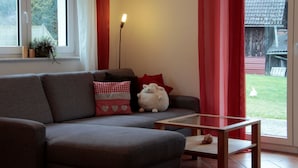 Una sala de estar con un sofá gris, una mesita y una lámpara.