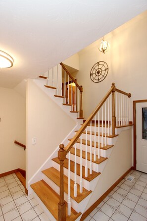 Staircase with a handrail and decorative metal piece above, set against a light-colored backdrop.