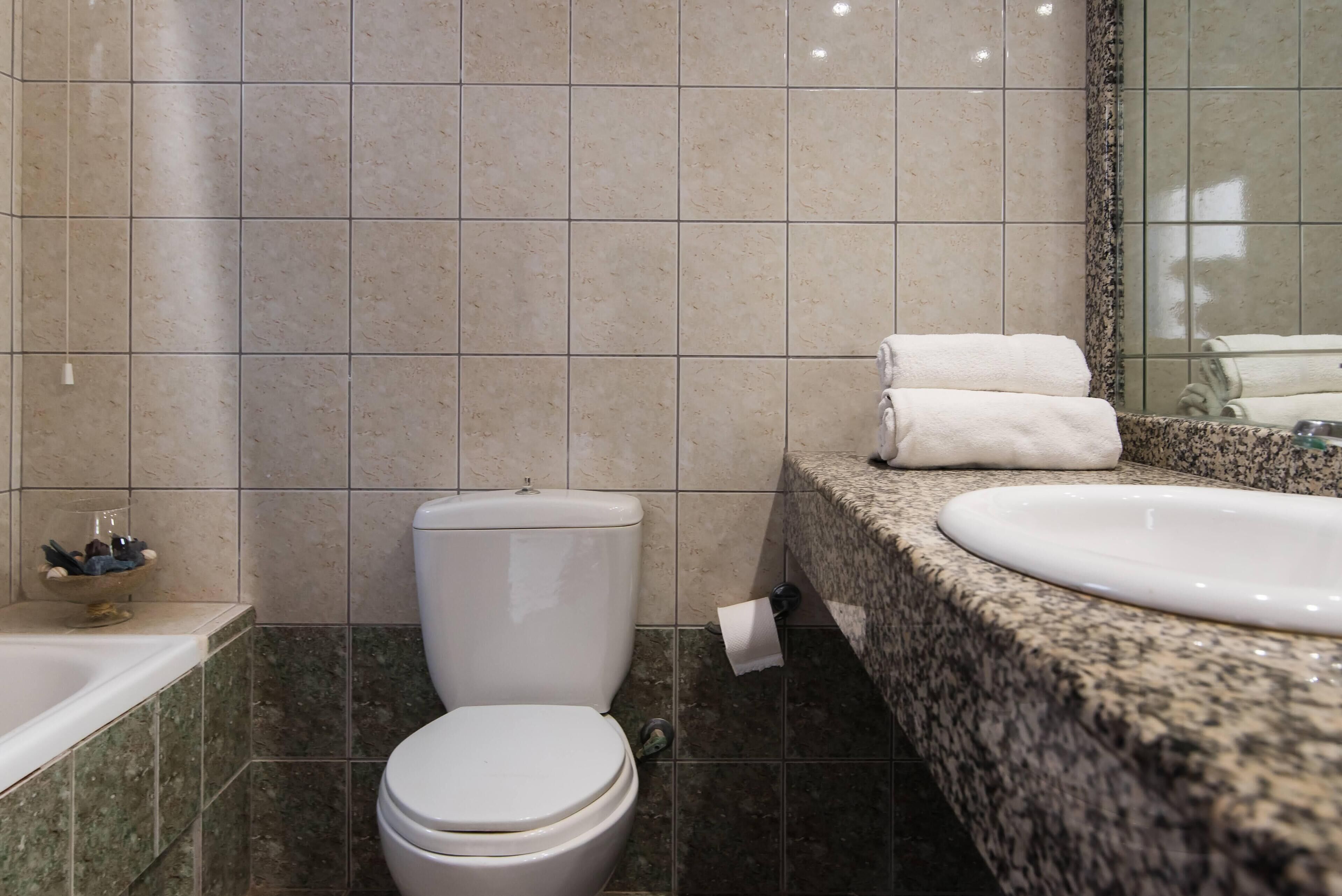 A bathroom with a toilet, sink, and bathtub.
