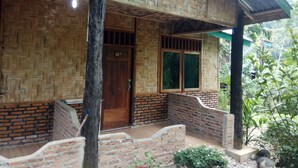 Uma casa tradicional com porta de madeira, janela com grades e fachada de tijolo.