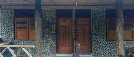 A building with a stone facade, wooden doors, and a covered entrance area.