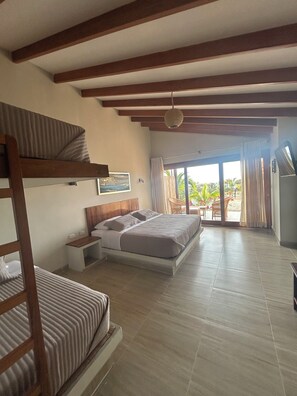 A bedroom with a bunk bed, a single bed, a bedside table, a nightstand, a ceiling fan, a window with curtains, and a view of the outdoors. - El Samay Hotel Boutique (Canoas de Punta Sal)