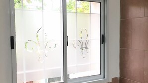 Una finestra con vetro smerigliato e cornice bianca.
