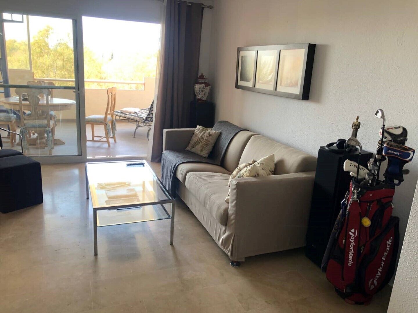 Un salon avec un canapé, une table basse et un sac de golf.
