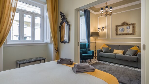 Una habitación de hotel con una cama grande, un banco, un sofá y una silla.