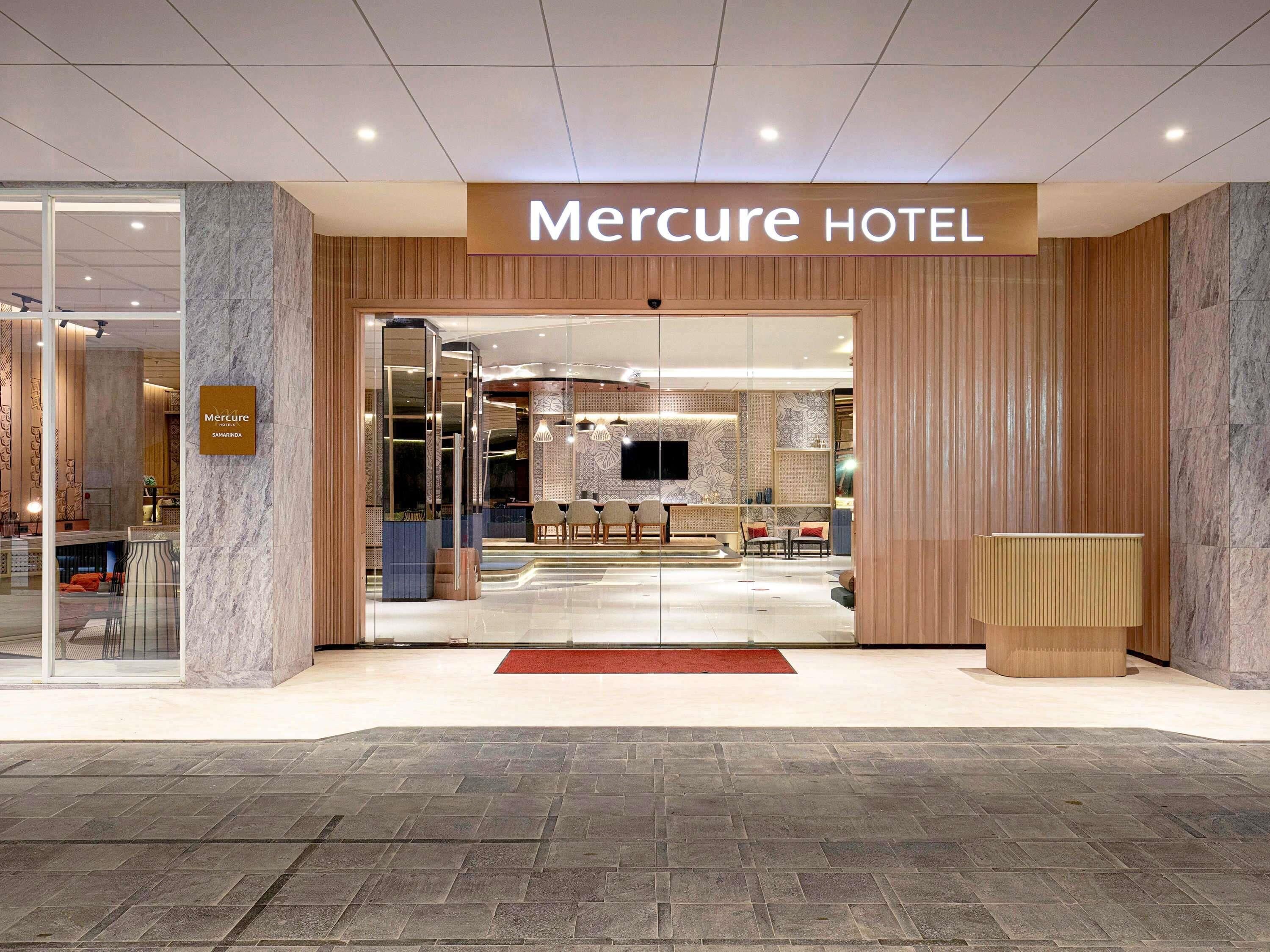 L’entrée de l’hôtel Mercure, avec son comptoir d’accueil, son espace salon et son aménagement intérieur moderne.
