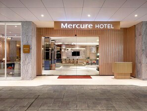 The entrance to Mercure Hotel with a reception desk, seating area, and a modern interior design. - Mercure Samarinda (Samarinda)