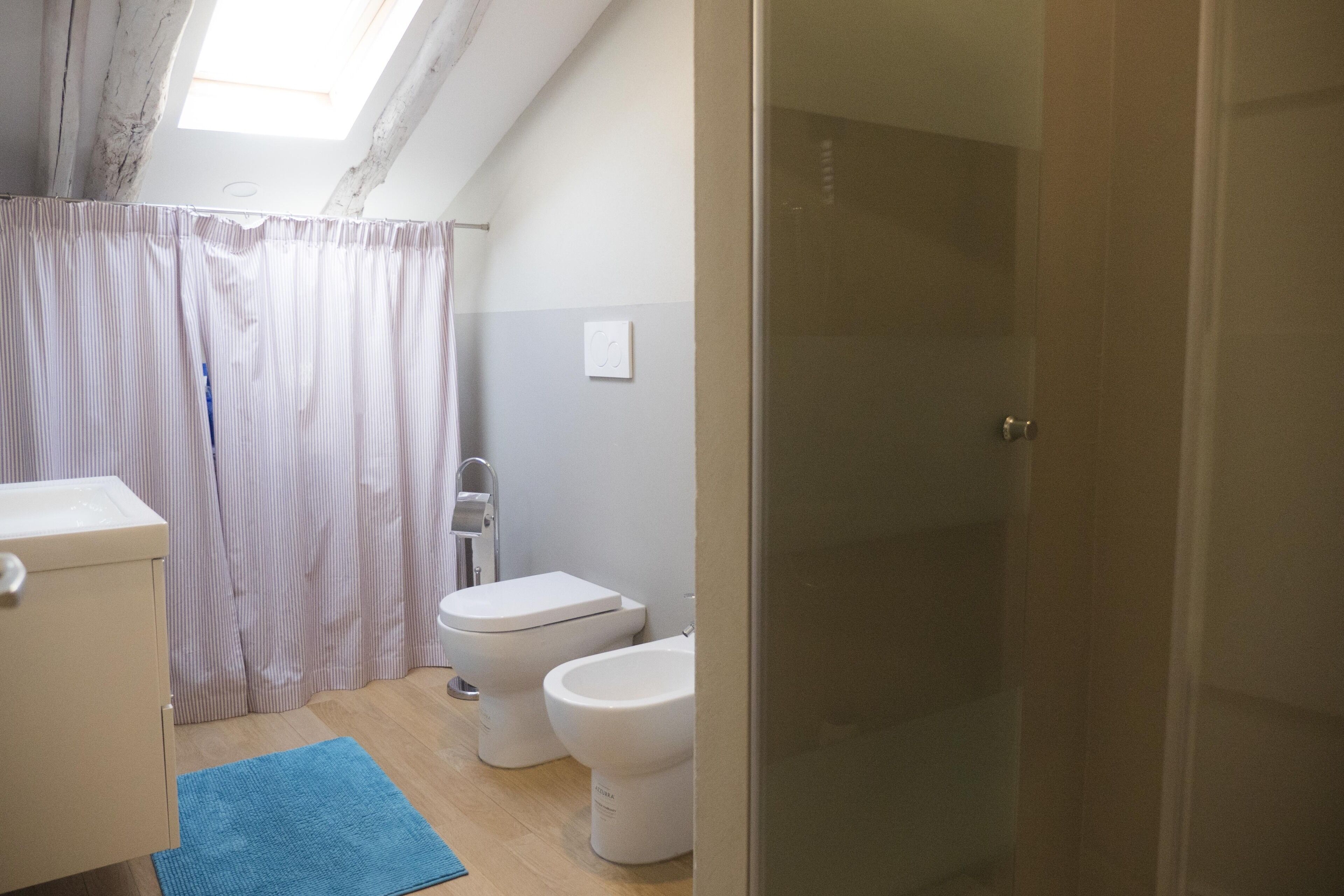 A bathroom with a shower, toilet, and sink.