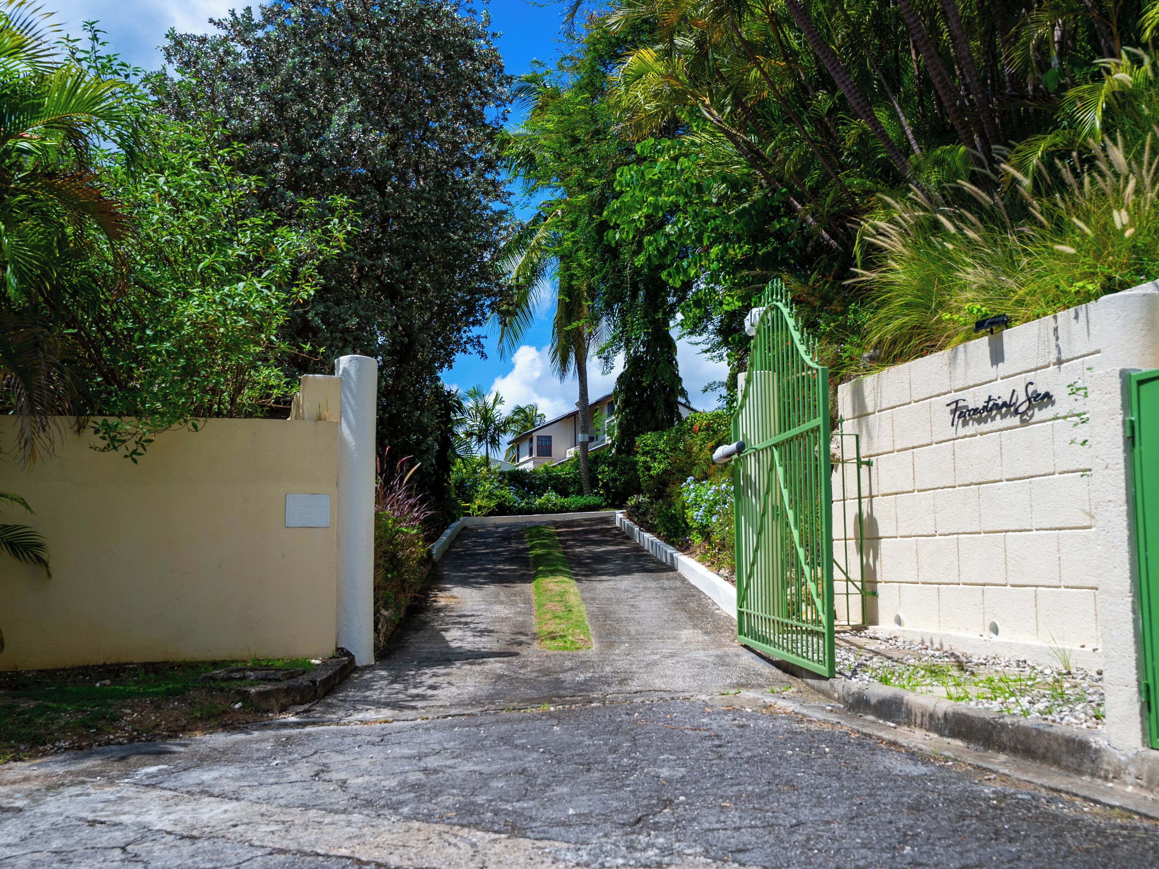 Un étroit sentier mène à une entrée fermée par un portail sur lequel on peut lire : « Farnborough Sea ».