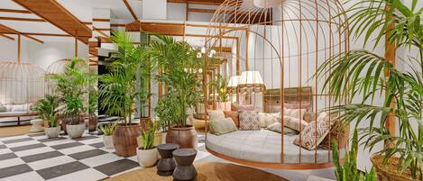 Un salon moderne avec un sol à carreaux, un fauteuil suspendu et diverses plantes en pot.