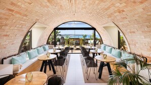 A restaurant with brick walls, outdoor seating, and a view of the sea. - Aubamar Palma Resort (Palma de Mallorca)