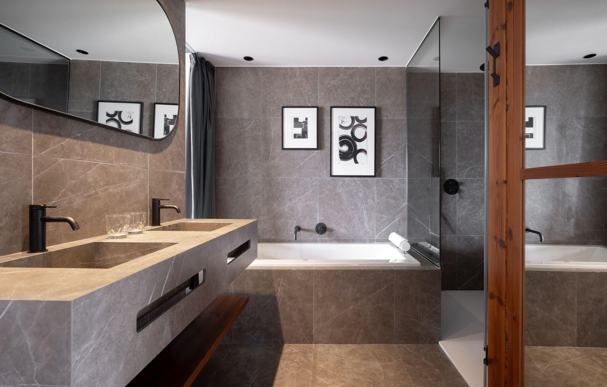 Une salle de bain moderne avec deux lavabos, une baignoire et une douche.