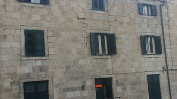 A stone building with multiple windows and doors, featuring a traditional architectural style.