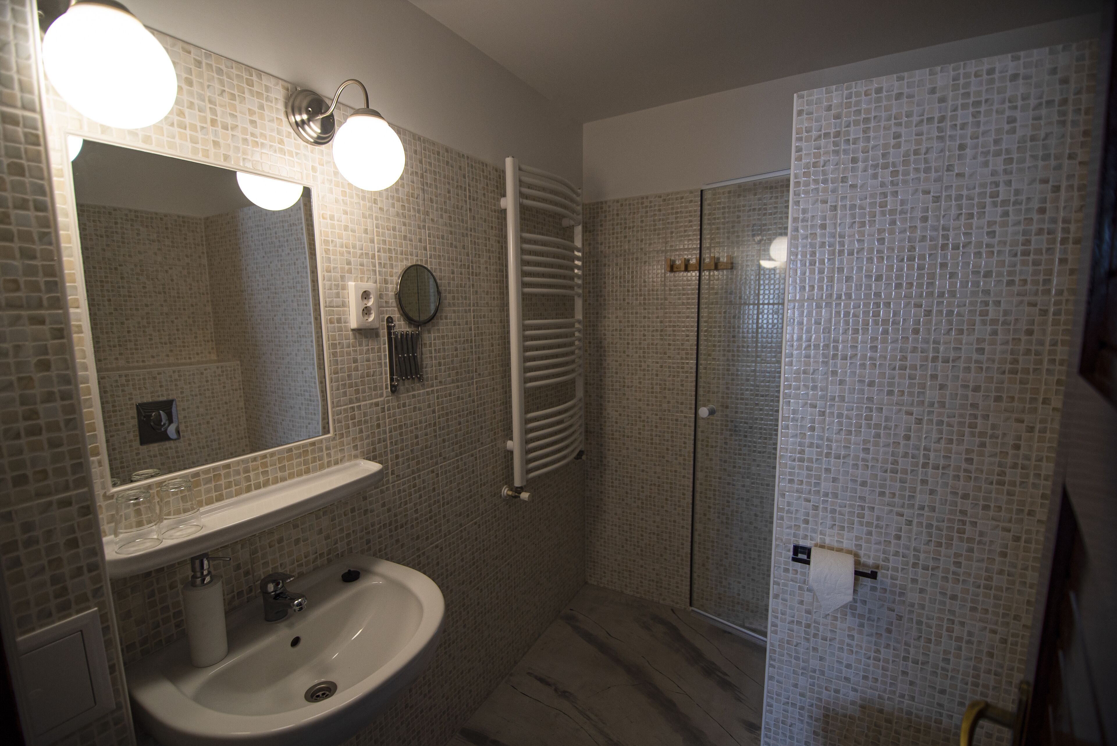 Un baño con lavamanos, espejo y ducha.