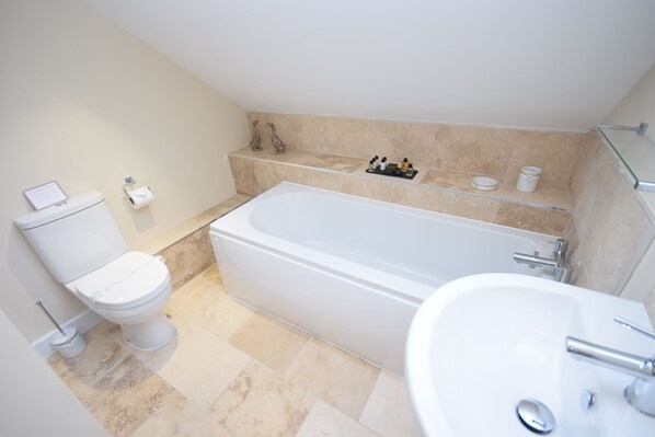 Un baño moderno con inodoro, bañera y lavabo.