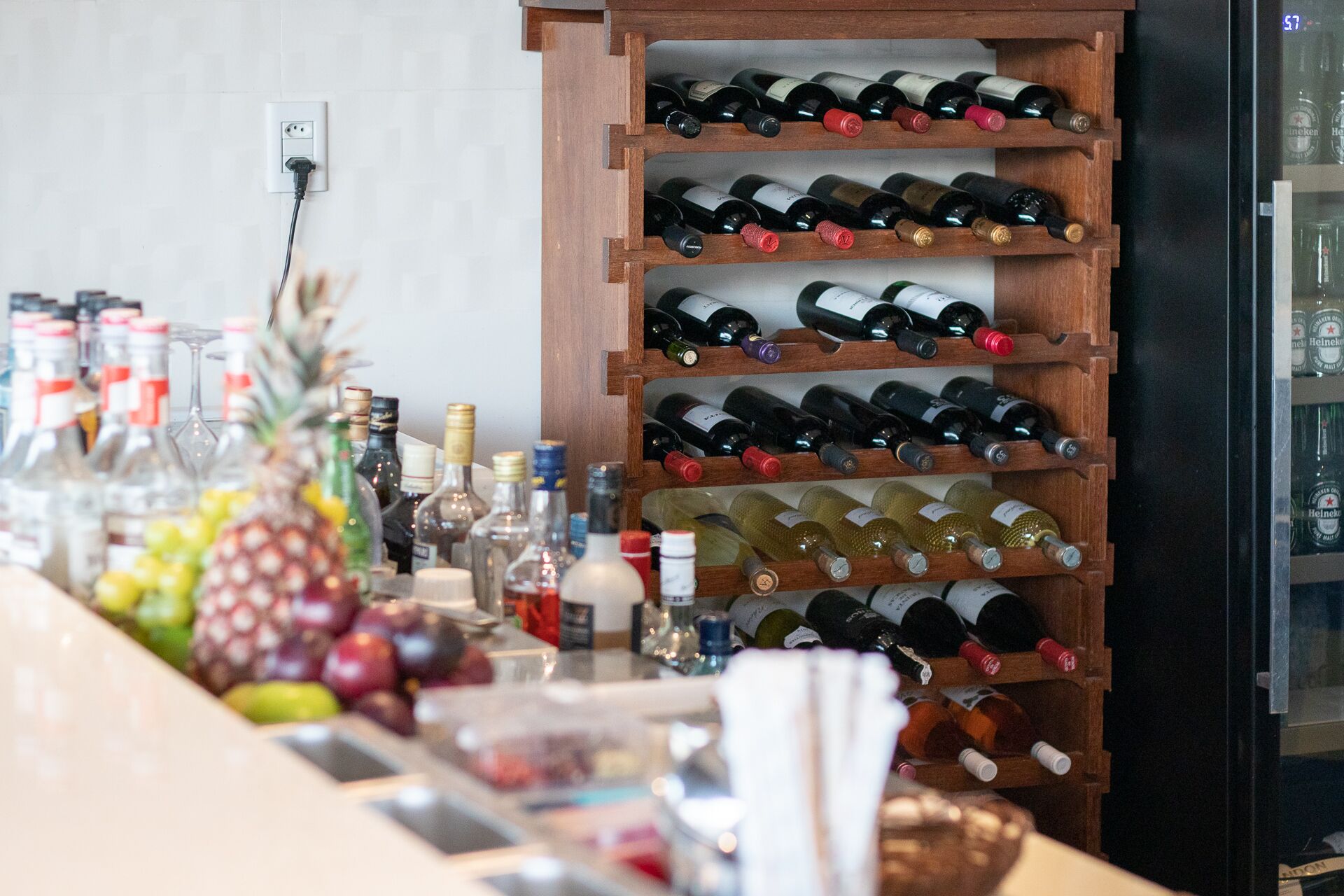 Una botellera de madera con varias estanterías que sostienen diferentes botellas de vino.
