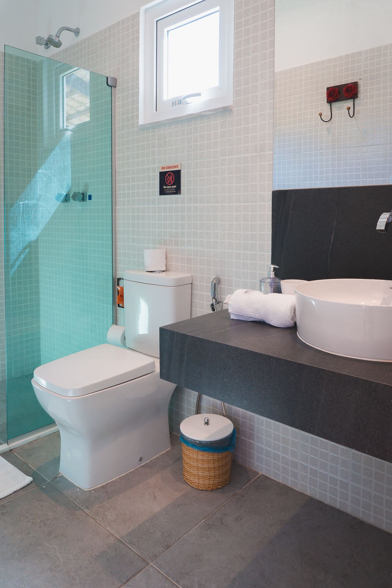 A bathroom with a glass shower enclosure, a toilet, a sink, and a bidet.